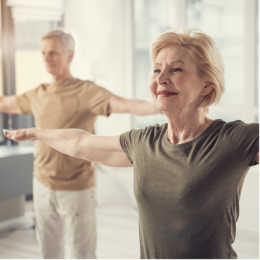 Pareja de adultos mayores realizando ejercicios.